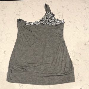 Flirty one sleeve blouse with eye catching bling. NWOT